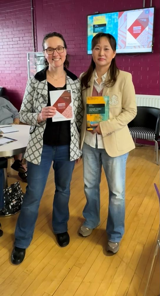 Two people holding books in an interior