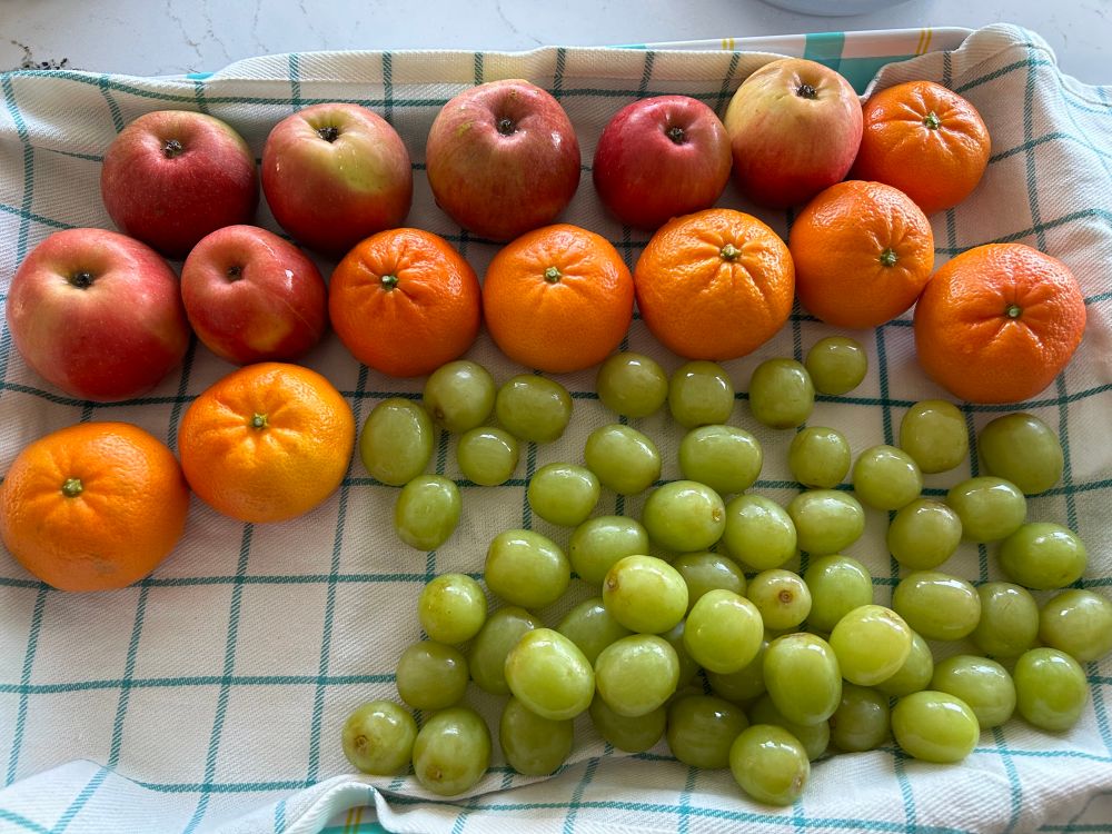 Photo of cleaned apples, mandarines and seedless green grapes 