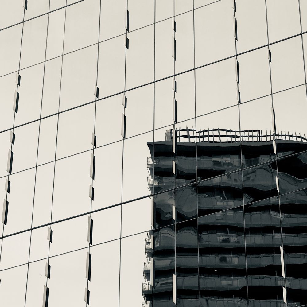 A building looking wibbly as it is reflected in another building