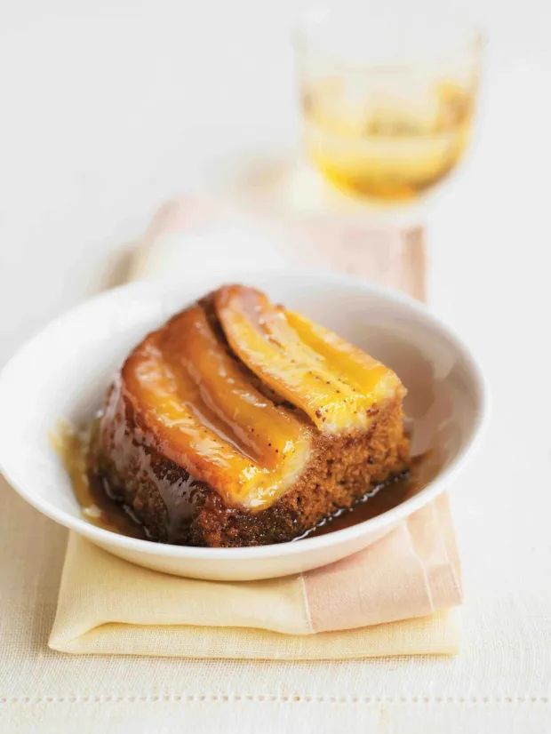 A slice of Topsy-Turvy Banana Gingercake topped with caramelized bananas and drizzled with golden syrup.