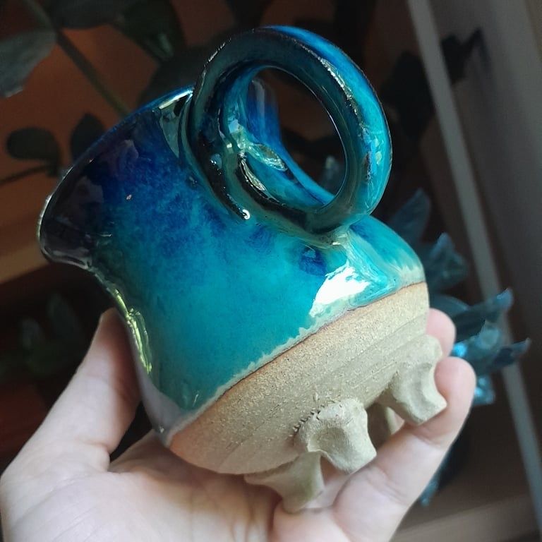 A mug with a blue black glaze and small feet