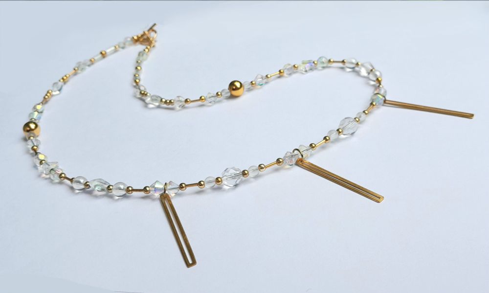 23" necklace with iridescent glass, metal beads, brass pendants and a gold-coloured toggle clasp.