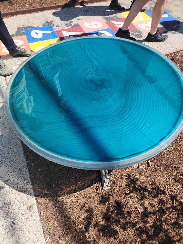 A transparent, spinning table filled with water, blue dye, and mica powder, creating fluid patterns when it is turned. 