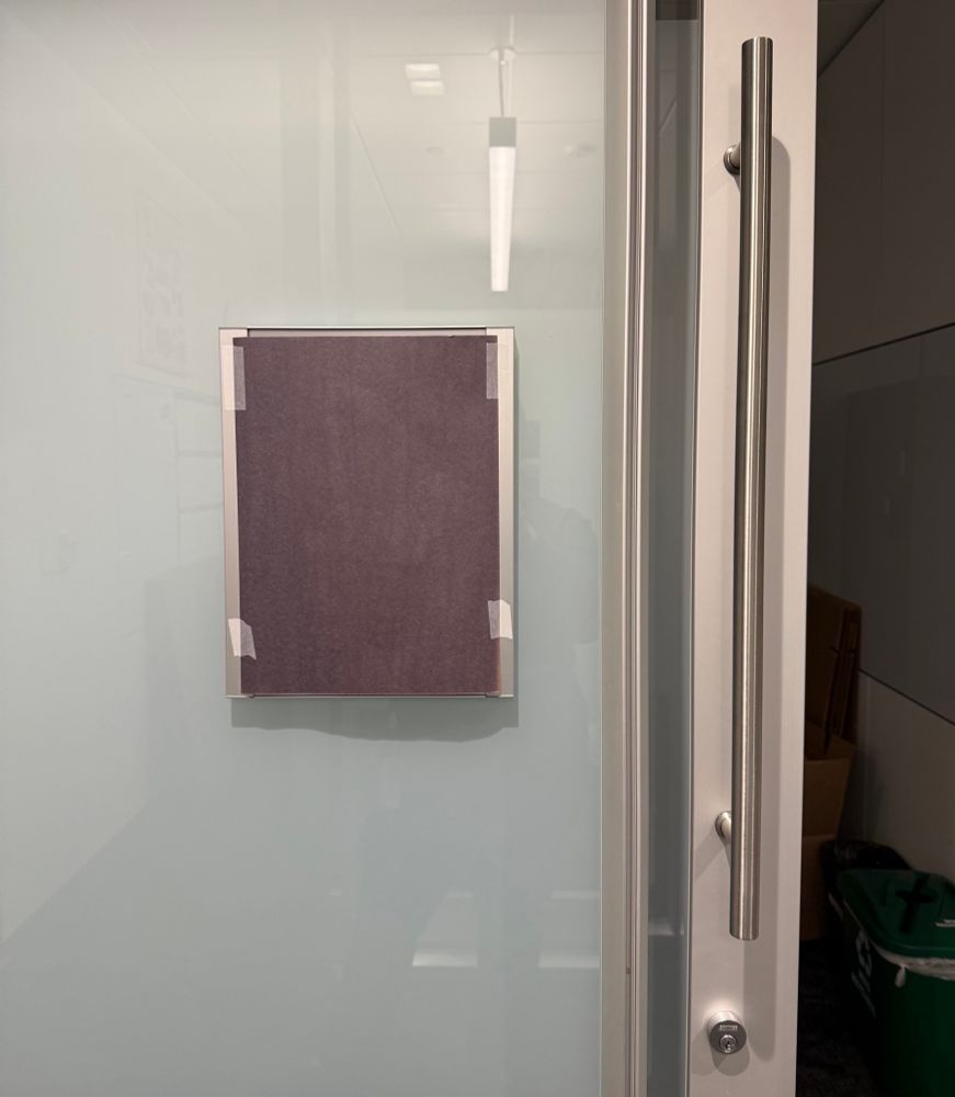 The office door of my colleague, fired from his job with no notice. His nameplate is covered in black paper.