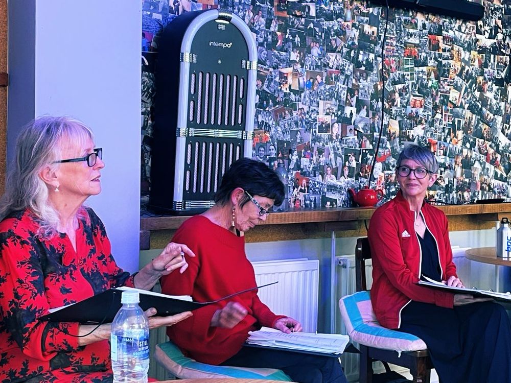 Sharon Morgan, Delyth Wyn and Maria Pride sitting reading from scripts.