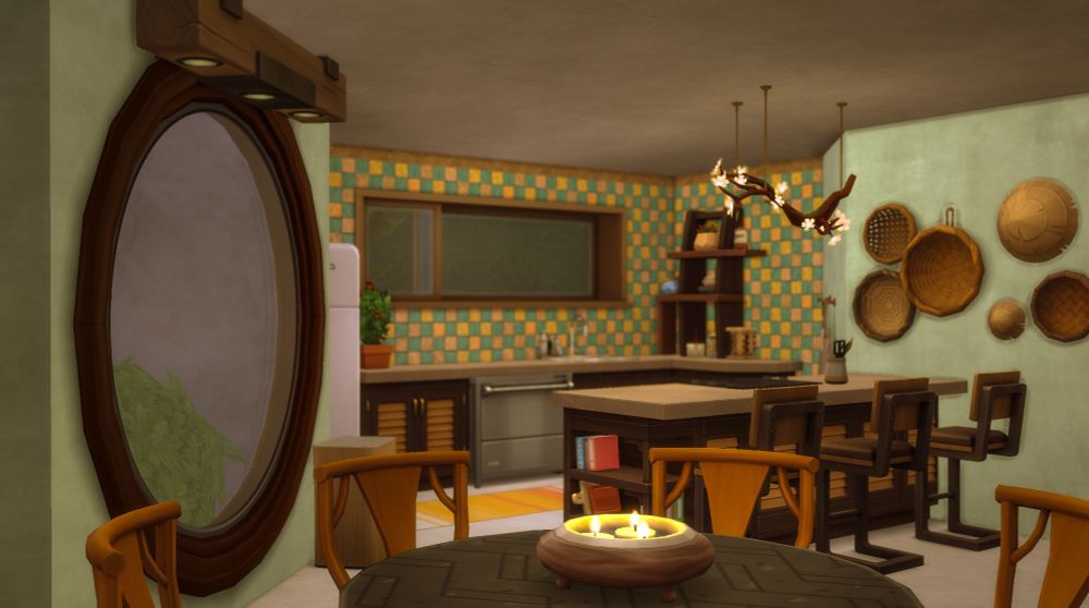 Candles glow on the tabletop in the foreground of an open-concept kitchen and dining area.
