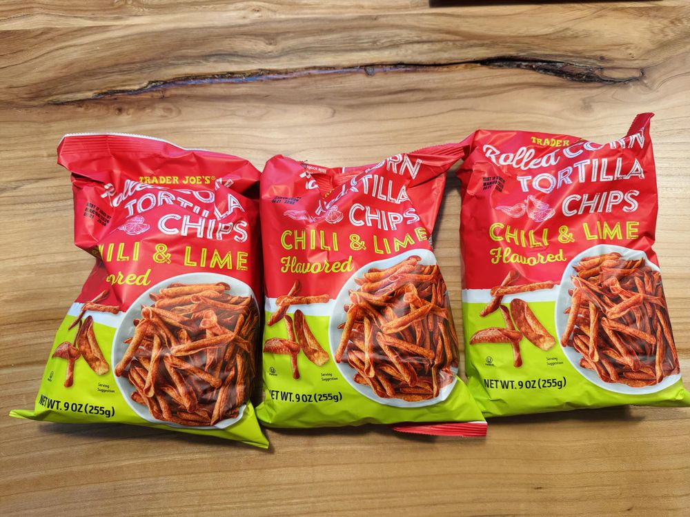 three bright red and green bags of spicy chips from trader joes.