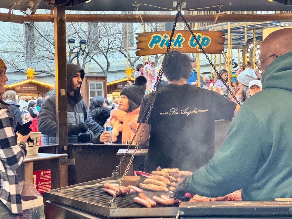 a couple in winter garb waits for their food at the sausage grill in the christmas village in philadelphia on the day after thanksgiving 