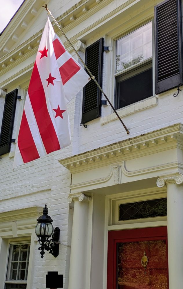 A flag of Washington DC hanging over a door in the District.