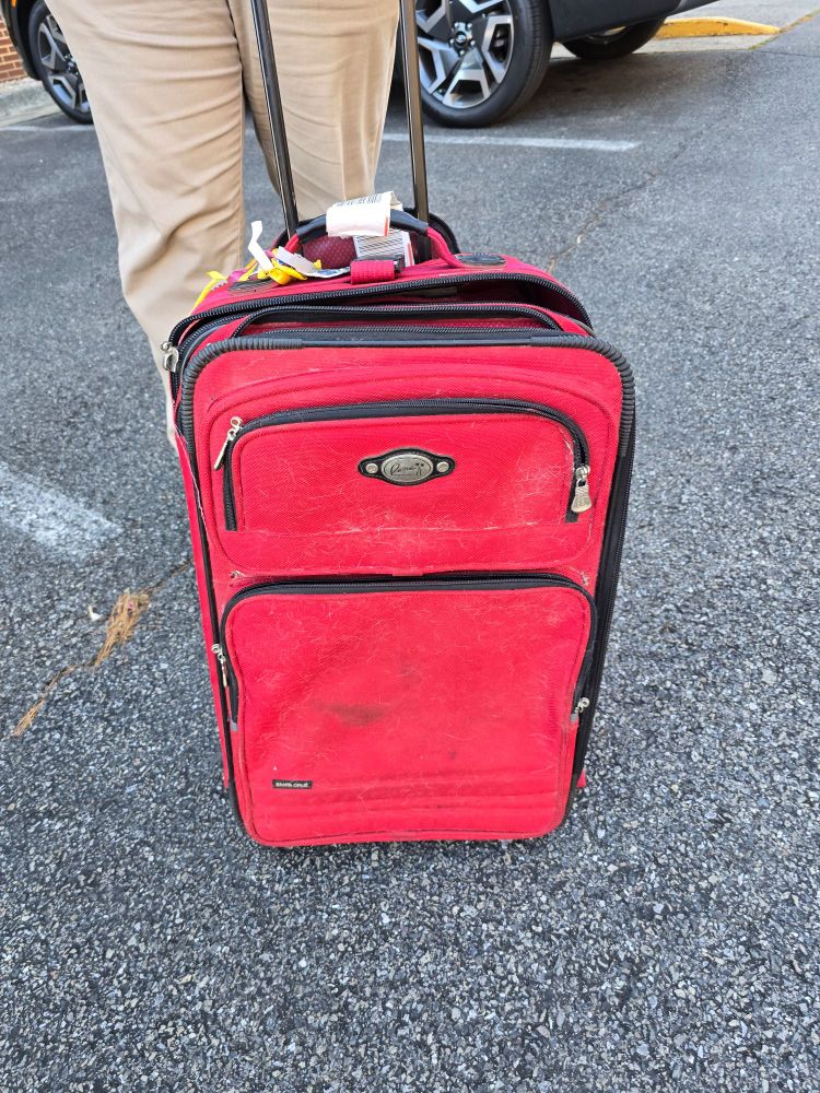 Old and battered red suitcase.