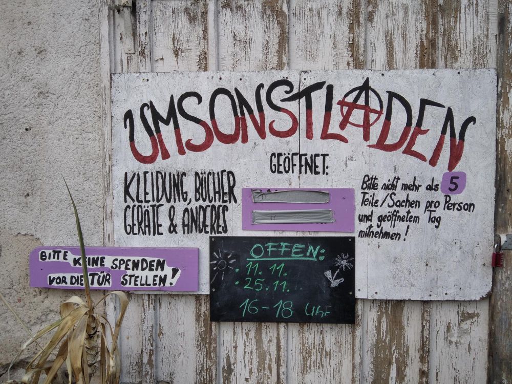 Schild an Scheunentor: "Umsonstladen geöffnet 25.11. 16 bis 18 Uhr"