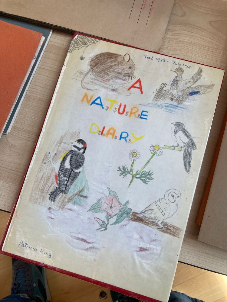 A cover of a school book titled A Nature Diary with illustrations of birds and a mouse