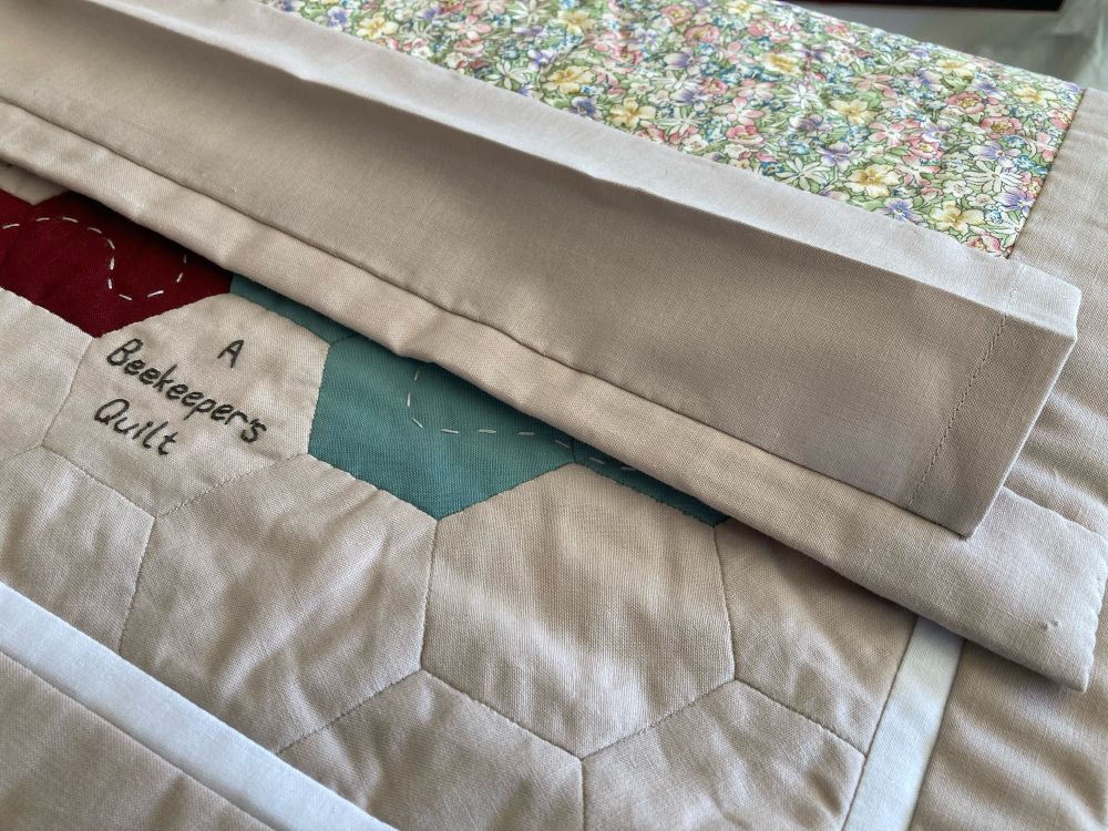 A fabric sleeve stitched to the back of a quilt