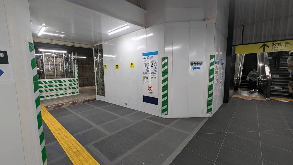 増設ホーム（手前右）と従来ホーム（左奥）をつなぐ通路。閉鎖した線路をまたいでいるが上から下まで鉄板で覆われている。【撮影：草町義和】