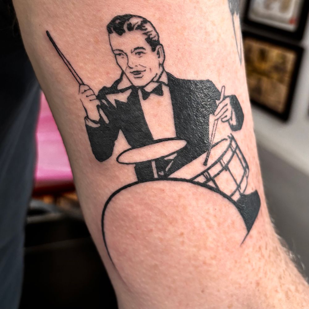 Tattoo of 1950s-style illustration of man playing drums