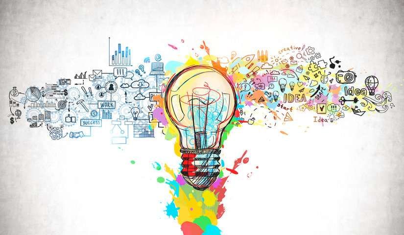 Drawing of a lightbulb in several colors. The lightbulb is accented by multi-colored paint splatters. To the left of the lightbulb are drawings of charts, speech bubbles, and the words 'work' and 'success', all in shades of blue and black. To the right are drawings of smaller lightbulbs, puzzle pieces, and the words 'idea,' 'creative,' and 'start'.