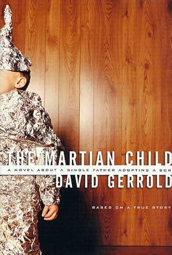 Cover of a trade paperback book. The background of the image is a wood-paneled wall. On the left side is a young boy, only about half of his body visible. He is wrapped in aluminum foil except for his left hand, and part of his face, and with a tin-foil hat too. The title is in a white font, in all caps: THE MARTIAN CHILD. Below that is a white banner across the cover, the text in black: A Novel About a Single Father Adopting a Son. Below that is the author's name: DAVID GERROLD, and below that in a much smaller font: Based on a True Story.