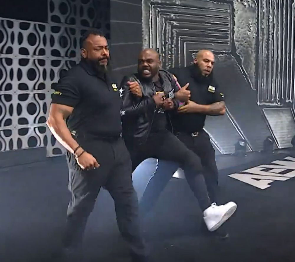 stokely hathaway being dragged to the ring by 2 burly guards