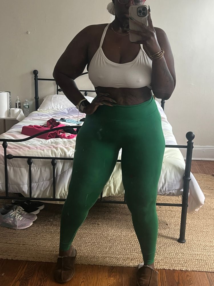 The author in green fabletics leggings, a white sports bra, and a white head wrap. 
