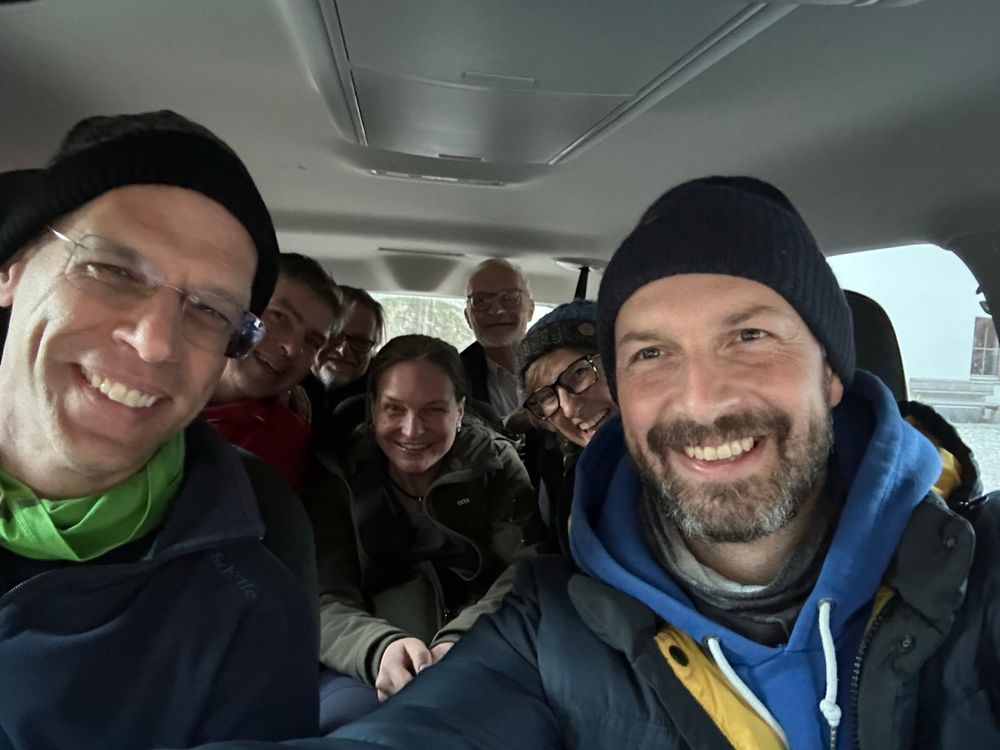 group picture of 7 persons in a car