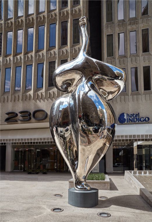 A highly reflective sculpture in the form of a fertility figure standing outside the Indigo Hotel in downtown Atlanta GA 