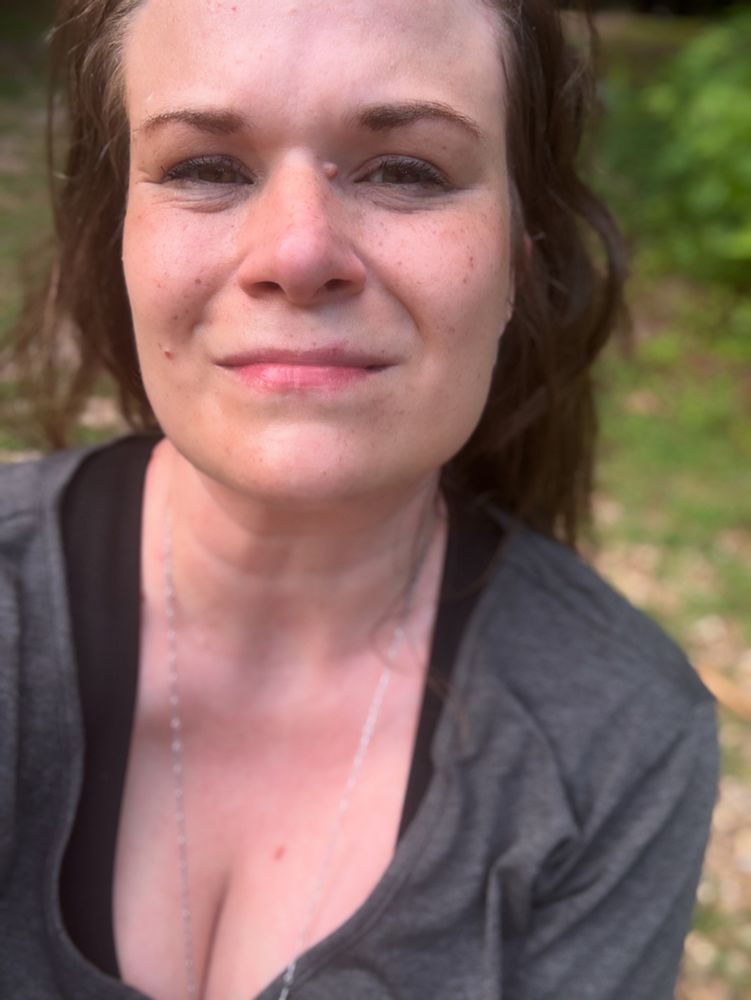a sweaty woman in a low cut grey shirt 