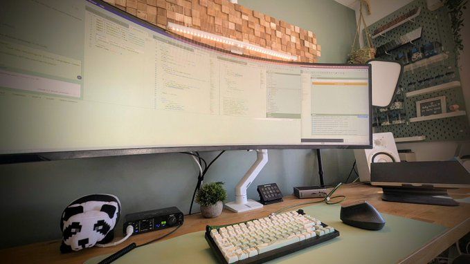 A BenQ ScreenBar Pro mounted on a computer monitor, illuminating a clean and organized workspace.