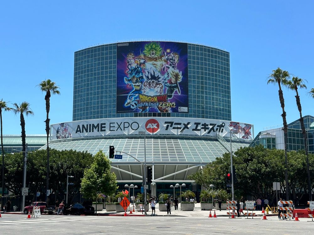 An outdoor view of the Los Angeles Convention Center's South Hall, decorated with a banner of Anime Expo and a poster of Dragon Ball: Sparking! Zero.
