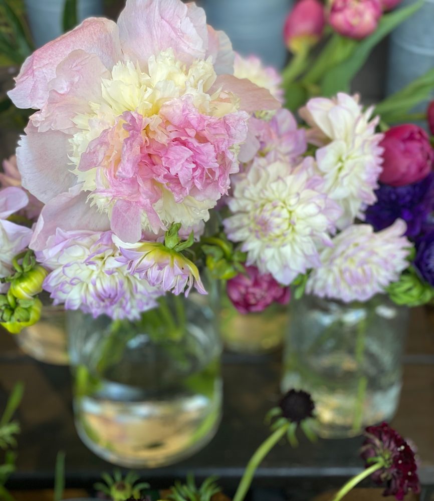 Beautiful bouquet of white, pink, and lavender flowers in a clear vase. 
