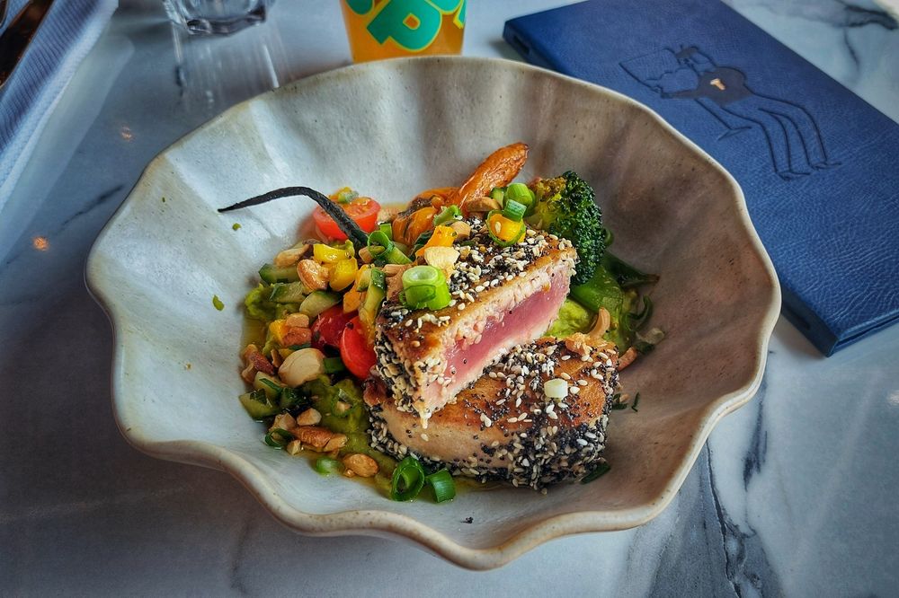 Mi-cuit de thon pané au sésame, purée de petit pois wasabi, sauce vierge méditerranéenne, carottes fanes & asperges, noix de cajou, herbes