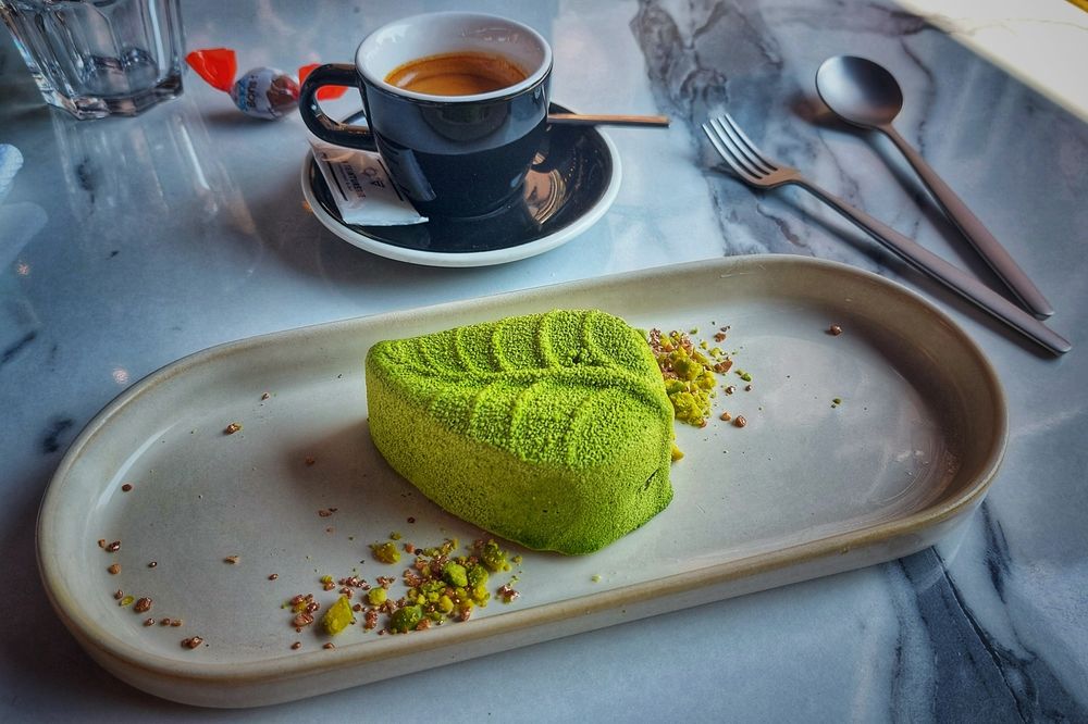 Entremet noisette en forme de feuille et une tasse de café expresso