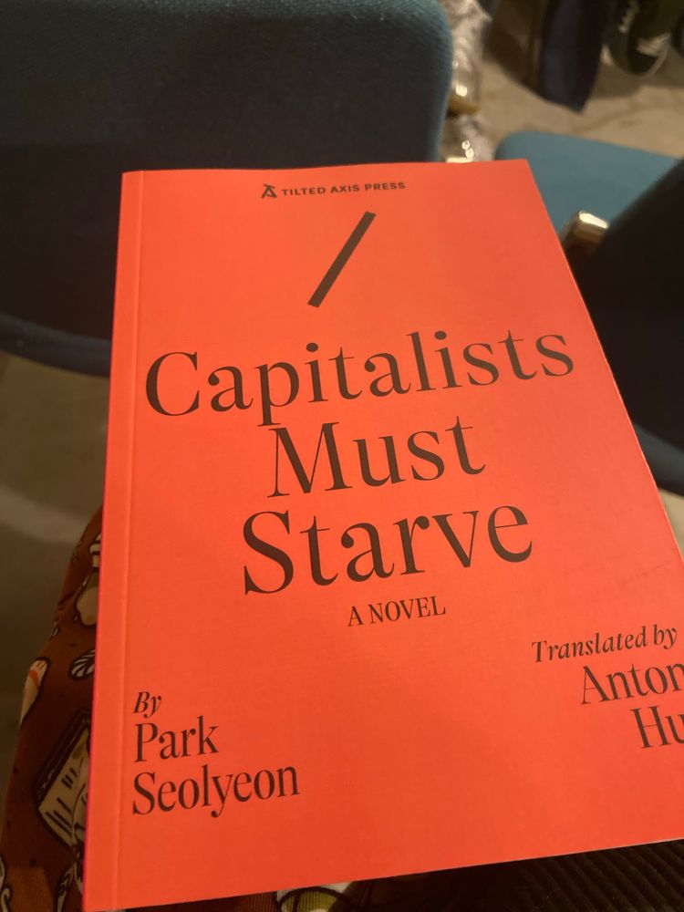 Photo of the cover of the novel ‘Capitalists Must Starve’ at an even for the book in Mount Florida Books this evening