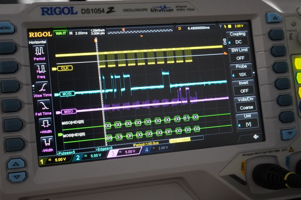 The photo shows the screen of a digital oscilloscope. On the screen three three signals are visible, labelled CLK, MOSI and MISO. Alls show digital patterns with a peak to peak voltage of about 5V and in 8 bit groups that last about 1 millisecond each. Below the signals is the result of SPI decoding, showing hex values for the MISO and MOSI signals. MOSI data is 0x88 0x33 0x0f 0x00 0x00 0x00 0x0f 0x00 0x00 0x00. MISO data is 0x00 0x00 0x00 0x00 0x00 0x00 0x00 0x00 0x81 0x00.