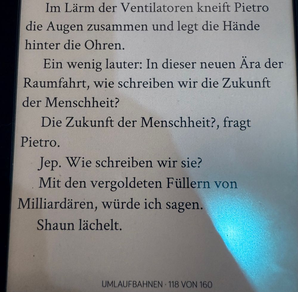 Foto von Ausschnitt, ebook Samantha Harvey „Umlaufbahnen“

Im Lärm der Ventilatoren kneift Pietro
die Augen zusammen und legt die Hände hinter die Ohren.
Ein wenig lauter: In dieser neuen Ara der Raumfahrt, wie schreiben wir die Zukunft der Menschheit?
Die Zukunft der Menschheit?, fragt
Pietro.
Jep. Wie schreiben wir sie?
Mit den vergoldeten Füllern von
Milliardären, würde ich sagen.
Shaun lächelt.

