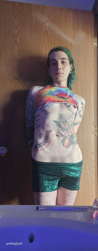 Creature standing against a door looking suggestively at the camera with its shirt mostly lifted