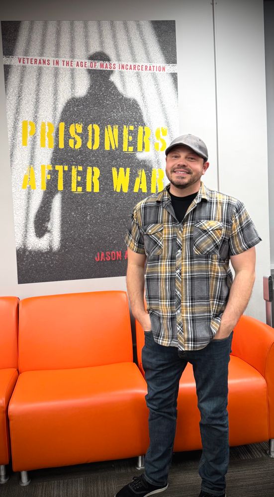 Me standing in front of a huge poster of my book, Prisoners after War
