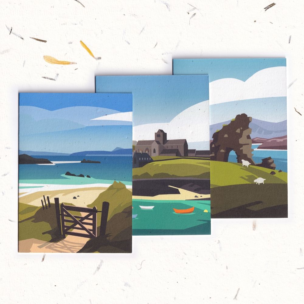 Three greeting cards. The first is of a beach on the Isle of Iona, with turquoise water and pristine sand. The second is of Iona Abbey with boats bobbing in the water. The third is of the old ruins on Iona with sheep grazing around. 