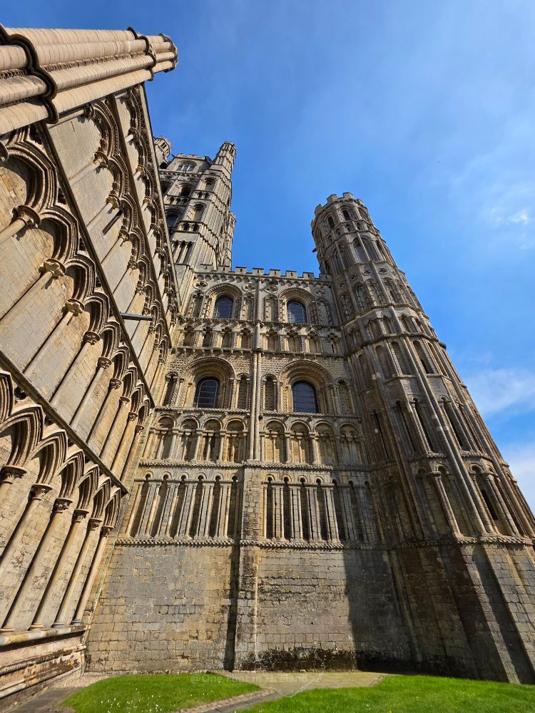 A worms eye view of the golden stone cathedral with arches and towers, so much fancy detail! 