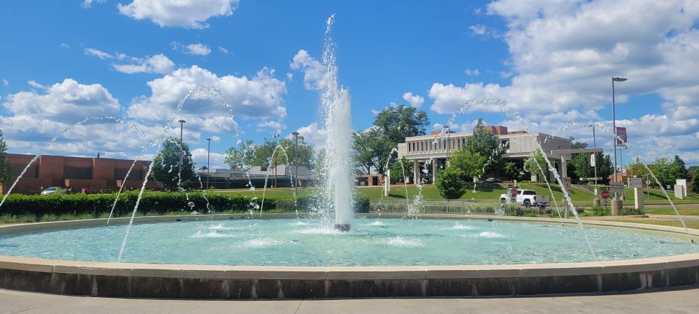a beautiful fountain on a beautiful bright blue and cloudy day.
