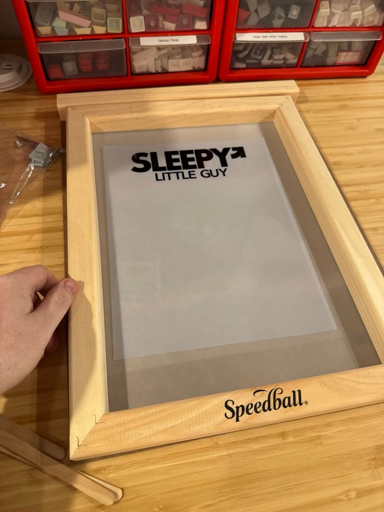 A screen printing transparency made in the  style of GEAR Berlin clothing that says “Sleepy Little Guy”