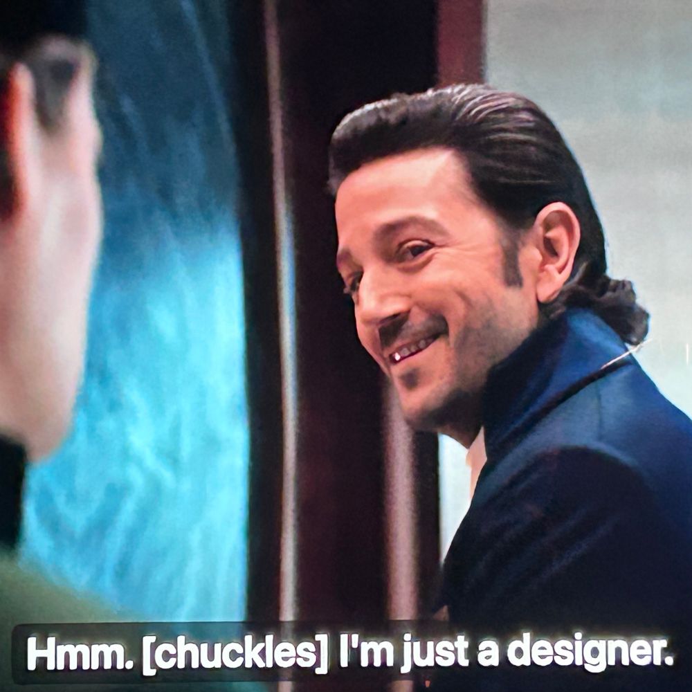 Screencap from Andor. Cassian smiling. Subtitle:  Hmm. [chuckles] I'm just a designer.