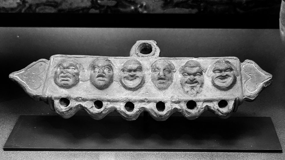 Au-dessus, un trou de remplissage. En dessous, six trous dans lesquels sont introduits des mèches pour éclairer.
La lampe est décorée de six visages, de face, posés sur la lampe.