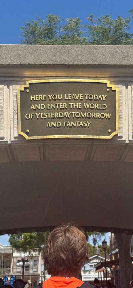 A photograph of a plaque that reads:

Here you leave today and enter the world of yesterday, tomorrow, and fantasy