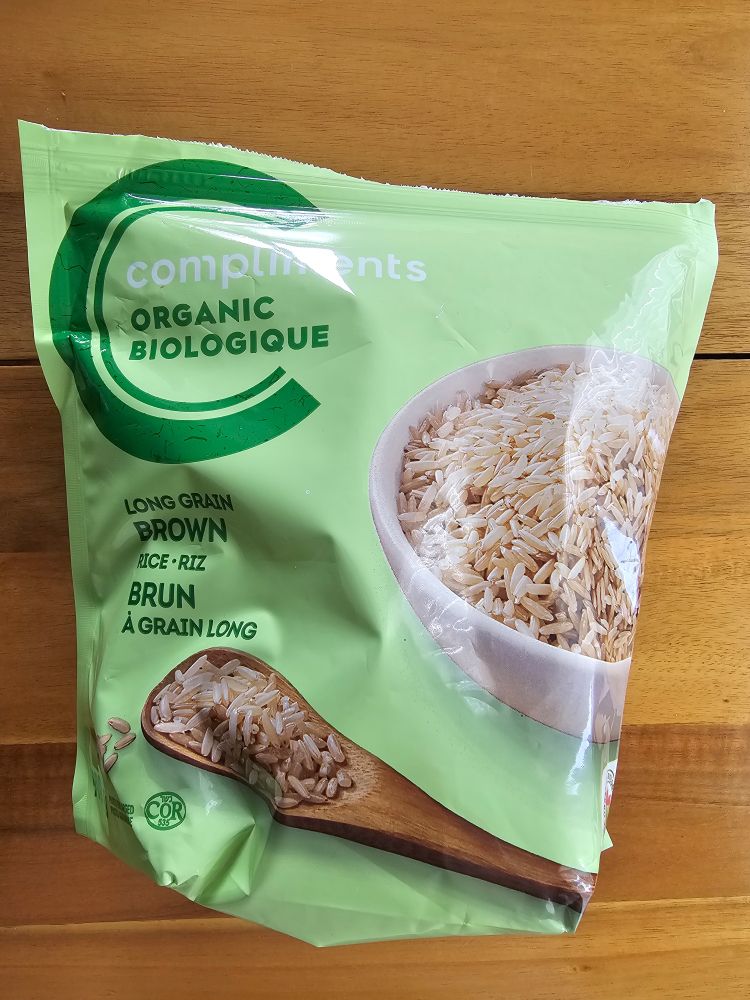 A bag of Our Compliments organic long grain brown rice on a wood table