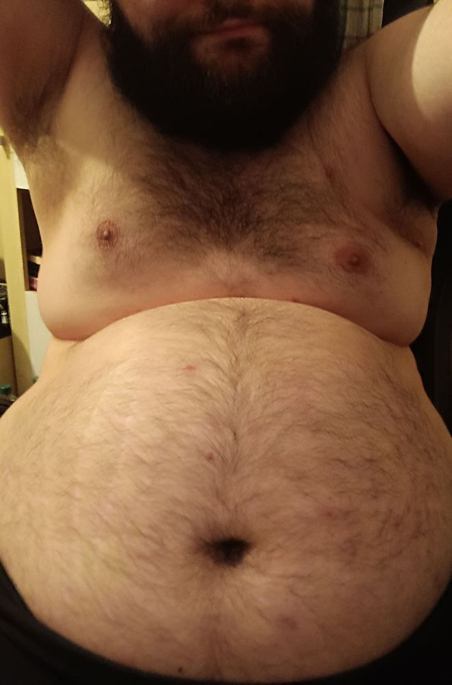 A bearded hairy chubby man showing his Belly