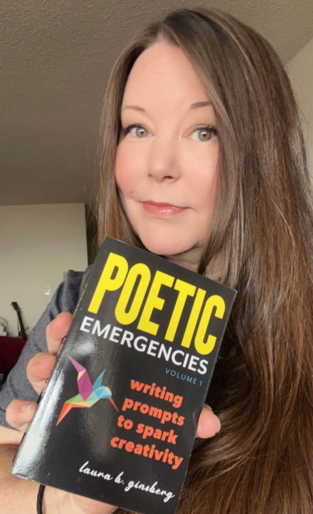 Author holding a book with the title Poetic Emergencies