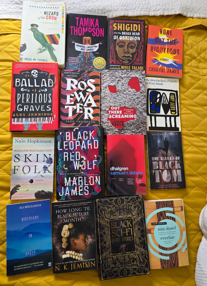 photo of 16 books by black authors spread across the yellow blanket on our bed in a 4 x 4 grid of books —

wizard of the crow by ngūgī wa thiong'o; unshod, cackling, and naked by tamika thompson; shigidi and the brass head of obalufon by wole talibi; none but the righteous by chantal james; the ballad of perilous graves by alex jennings; rosewater by tade thompson; out there screaming (horror anthology) edited by jordan peele; my life in the bush of ghosts by amos tutuola; skin folk by nalo hopkinson; black leopard, red wolf by marlon james; dhalgren by samuel r. delany; the ballad of black tom by victor lavalle; nigerians in space by deji bryce olukotun; how long 'til black future month? by n.k. jemisin; black sci-fi short stories (gothic fantasy) edited by tia ross; and everfair by nisi shawl.