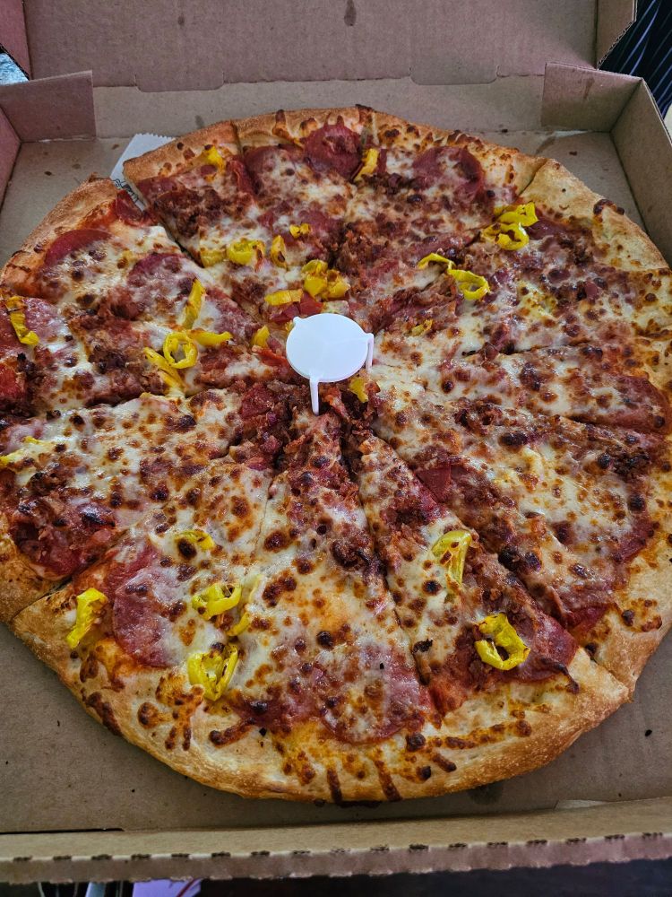 photo of pizza with pepperonis and banana peppers.