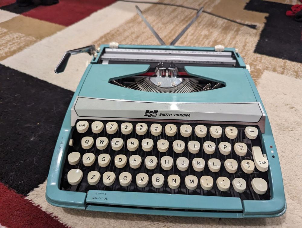 A bright blue Smith Corona manual typewriter.
