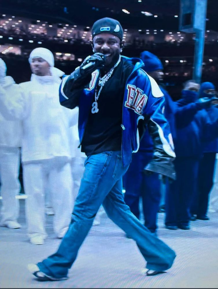 Kendrick Lamar committing murder 1 via smirk at the super bowl halftime show.